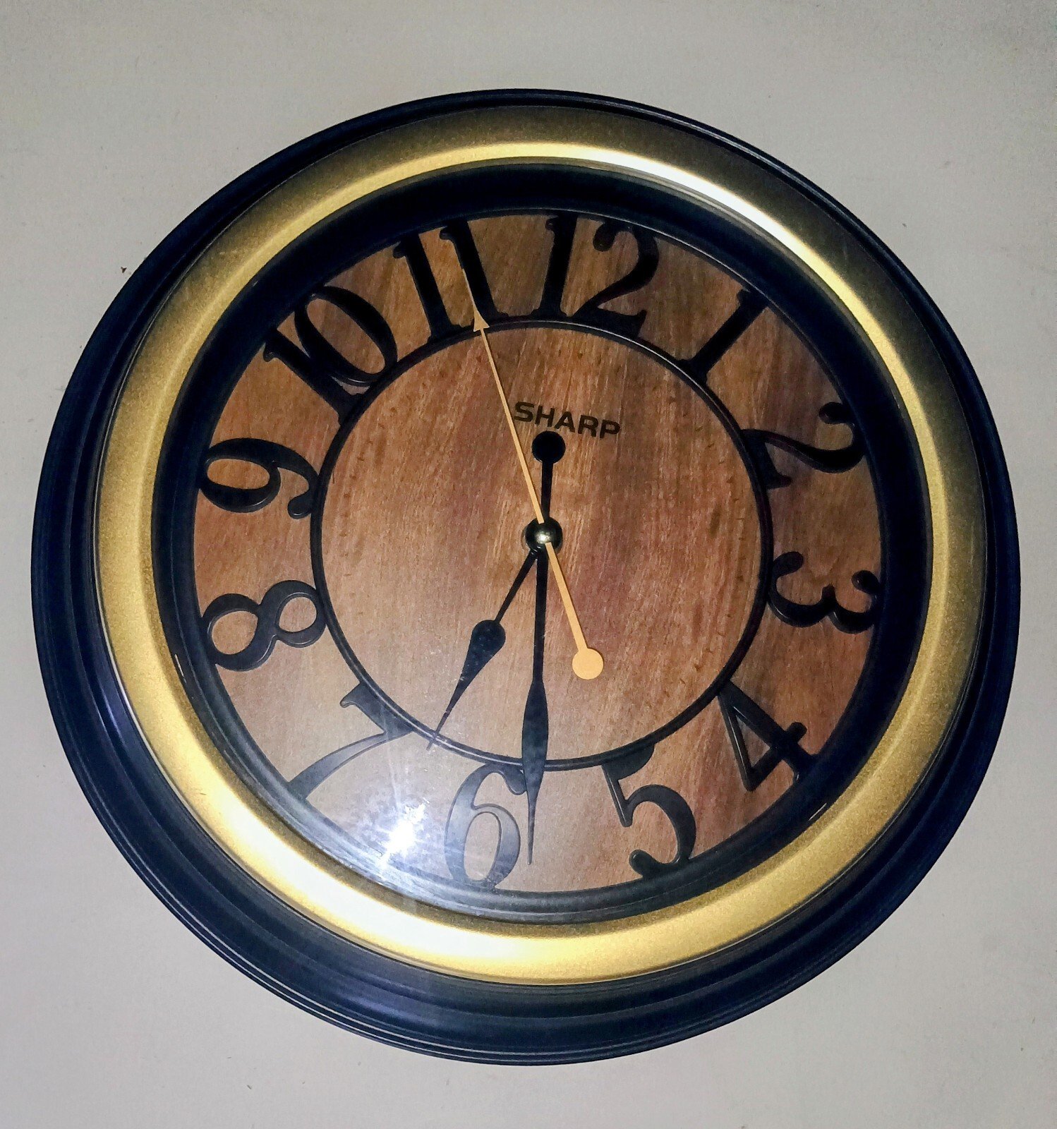 Beautiful Sharp Black & Gold Wall Clock With Wood Grain Backround